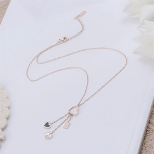 Collana in acciaio oro rosa con anello a cuore e tre ciondoli portafortuna alla moda