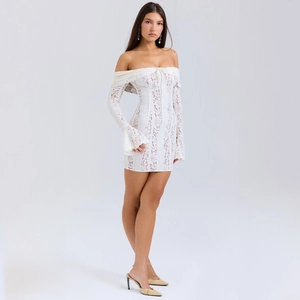 Detail of white lace mini dress with flared sleeves and delicate floral texture patterns
