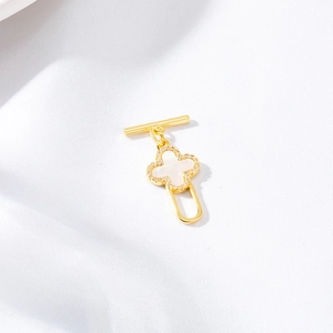 Golden clover pendant with white mother of pearl and crystal edge on white fabric