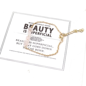 Detail of adjustable gold chain bracelet featuring raw irregular pink crystal stones