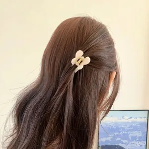 Pince à cheveux papillon crème chic en résine minimaliste montrée sur les cheveux