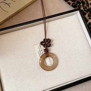 Detail of a vintage star pendant with wooden beads on a brown braided necklace cord