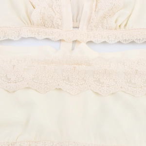 Robe élégante en mousseline abricot avec col en V, dentelle délicate et ourlet ondulé