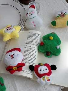 Close-up of assorted plush Christmas charms including Santa and tree on a table