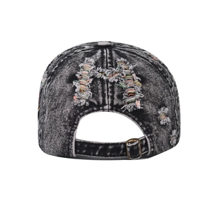 Detailed back view of washed denim cap featuring a distressed letter M with colored threads