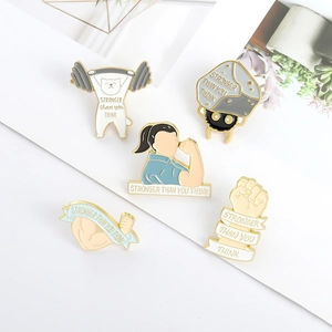 Detail of five enamel pins with Stronger Than You Think slogan and gym motifs