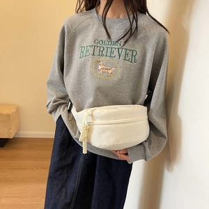 Modella che indossa un marsupio bianco in nylon con cerniera in corda intrecciata
