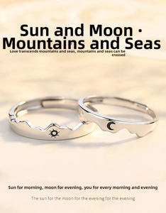 Macro shot of sun and moon couple rings featuring adjustable silver bands and wave motifs
