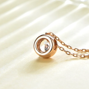 Macro view of rose gold circle pendant with sparkling cubic zirconia on a cable chain
