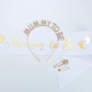 Detail shot of the Mommy to Be party set with gold rhinestone headband and satin sash