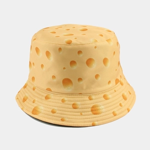 Detail of yellow reversible bucket hat with cheese pattern in textured cotton twill
