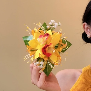 Detailed view of an elegant yellow fabric orchid hair clip with vibrant floral petals