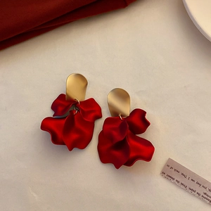 Detailed view of red petal tassel earrings with gold accents and silver needle studs