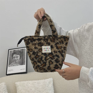 Close-up of leopard print plush tote bag with zipper closure and sozakka label