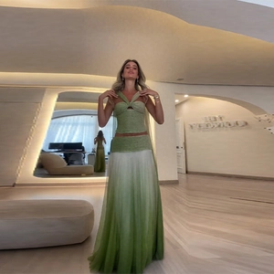 Detail of green halter top with cutout design and gradient maxi skirt for resort wear