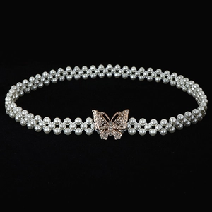 Elegant double-row pearl waist chain with a gold rhinestone butterfly buckle on black background