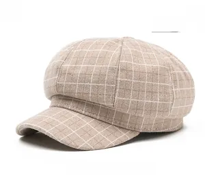 Close-up of beige plaid newsboy cap showing dense woven fabric and textured grid pattern