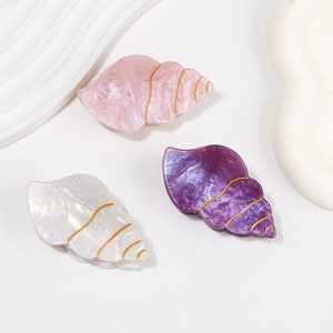 Chic shell-shaped acetate hair claws in pink, purple, and white with gold wire wrap