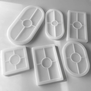 Detailed view of six white translucent silicone molds in oval and square shapes