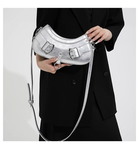 Detail of silver metallic crescent bag with wrinkled texture and large metal buckles