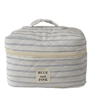 Quilted striped cosmetic bag with blue stripes and handle for portable makeup storage