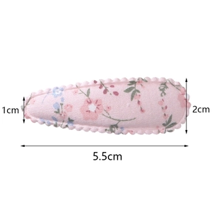 Detail of 5.5cm pink fabric teardrop hair clip with floral embroidery and scalloped edges