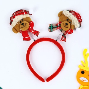 Détail d'un serre-tête de Noël en velours rouge avec oursons en tenues de fête