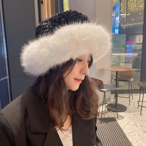 Close-up of fluffy black and white faux fur winter hat with earmuffs on a model