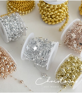 Detail of assorted gold and silver beaded chains on reels for Christmas tree decoration