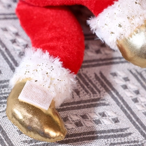 Detail of red Christmas doll featuring gold sequin boots and soft white plush trim