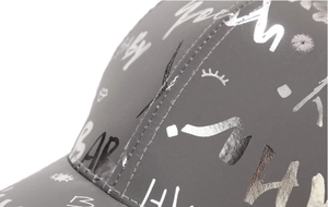 Detailed macro view of gray baseball cap fabric with silver reflective graffiti printing