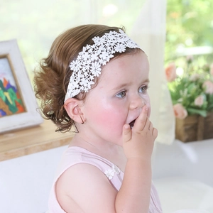 Detailed close-up of baby girl lace floral headband with delicate embroidery and soft elastic