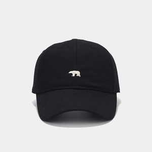 Detailed close-up of white polar bear embroidery on a classic black cotton baseball cap