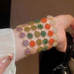 Elegant gold plated bracelets featuring colorful zircon flowers and pearls on a female wrist