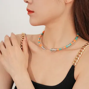 Bohemian beaded snake choker necklace with orange and green beads on a female model