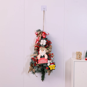 Detail of Christmas wreath with Santa, red berries and Merry Christmas wooden sign