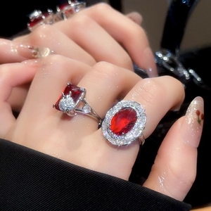 Close-up of luxury rectangular and oval red ruby rings with silver plating and sparkling diamonds