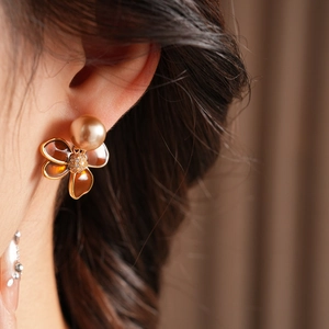 Gros plan de boucles d'oreilles trèfle ambré avec perles et zircons sur un mannequin