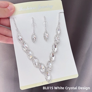 Detail of silver V-shaped necklace and drop earrings set with white marquise crystals