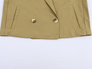 Detail of khaki linen blazer featuring tortoiseshell buttons and symmetrical pockets