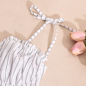 Detail of black and white striped dress showing lace-up straps and ruched chest fabric
