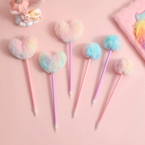 Detail of 6 rainbow plush ball and heart shaped pens on a soft pink background