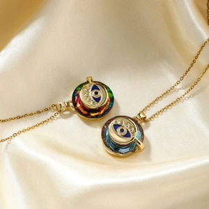 Elegant gold Evil Eye necklaces with rainbow crystal pendants on champagne silk background