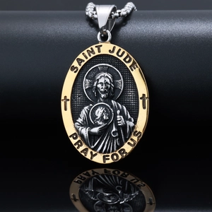 Macro detail of silver and gold Saint Jude pendant with 'Pray For Us' engraving