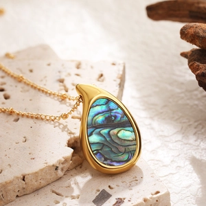 Macro shot of 18k gold plated waterdrop pendant with iridescent abalone shell inlay
