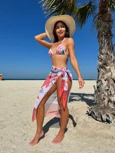 Three-piece floral print bikini set with matching mesh sarong and wide-brimmed straw hat