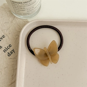 Close-up of brown acetate butterfly hair tie with France Handmade engraving on tray