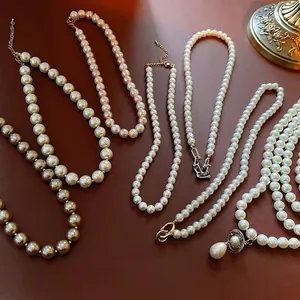 French vintage pearl necklaces with celestial pendants on a warm brown background