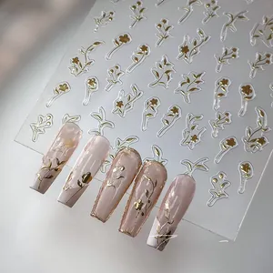 Close-up of M-332 gold 3D embossed floral nail stickers on pink gradient manicure