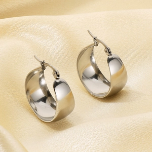 Polished silver stainless steel hoop earrings showcased on elegant silk fabric background